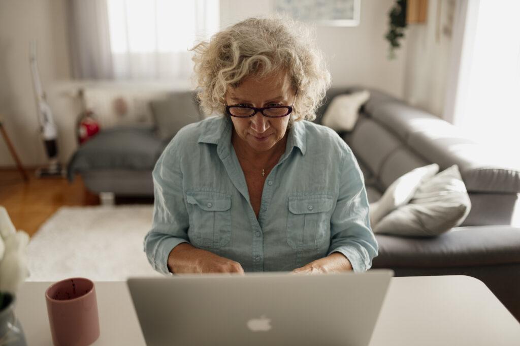 Older woman reviewing 2027 Medicare Part B premium information on a laptop